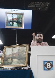 IMPRESSIONIST PAINTING: Auctioneer and Pop-culture Director Travis Landry takes bids on a reflective impressionist painting by Fritz Thaulow during an auction at the Bruneau & Co. Auctioneers gallery in Cranston. The painting sold for $7,000. / PBN PHOTO/MICHAEL SALERNO