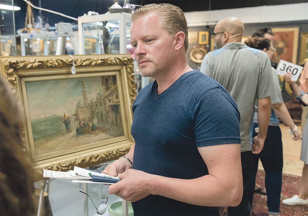 PLACING BIDS: Coventry resident Walter Sroka looks to place some bids on auction items at the Bruneau & Co. Auctioneers gallery in Cranston. / PBN PHOTO/MICHAEL SALERNO