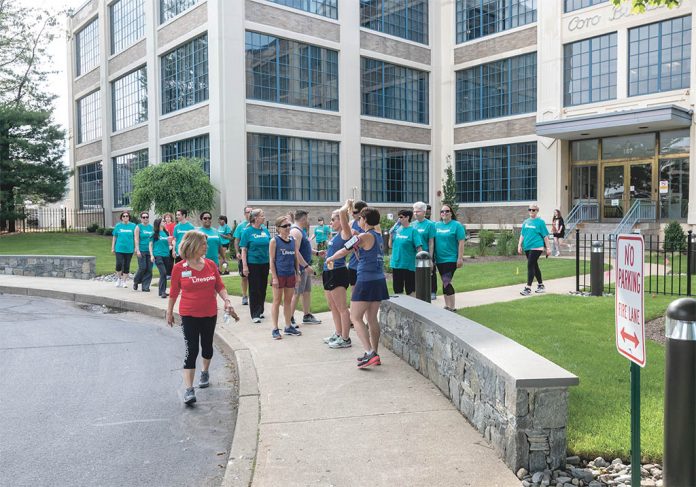 ON-SITE FITNESS: Team Lifespan members participate in one of the company’s corporate fitness outings near the offices on Point Street in ­Providence. / PBN PHOTO/MICHAEL SALERNO