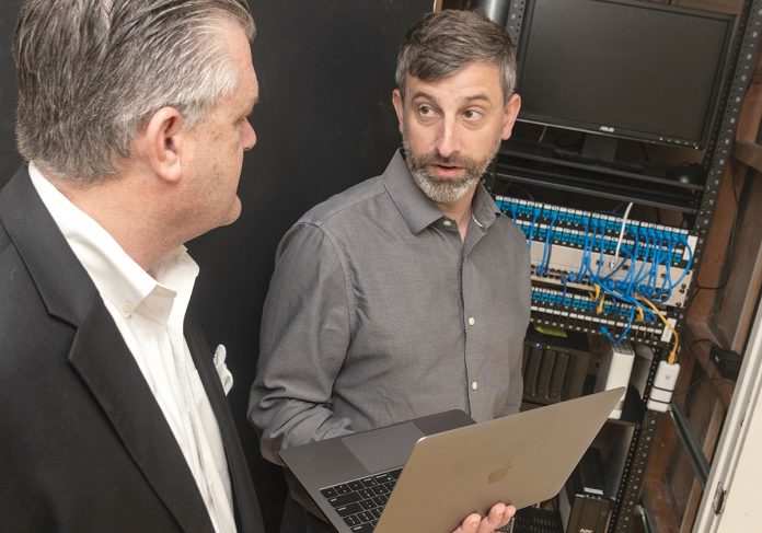 TECH SUPPORT: Terrence Boylan, left, CEO of PacketLogix, specializing in highly responsive information technology support, consulting and managed IT services, works with client Charles Antone, chief operating officer for Building Enclosure Science.  / PBN PHOTO/MICHAEL SALERNO