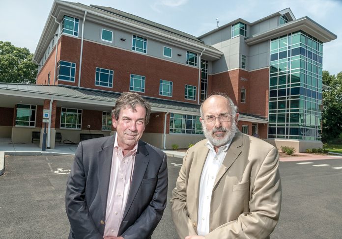 NEW STATION: Raymond Lavoie, left, executive director, and Dr. Michael Fine, senior clinical and population health officer, stand in front of Blackstone Valley Community Health Care’s new neighborhood health station in Central Falls.  / PBN PHOTO/MICHAEL SALERNO