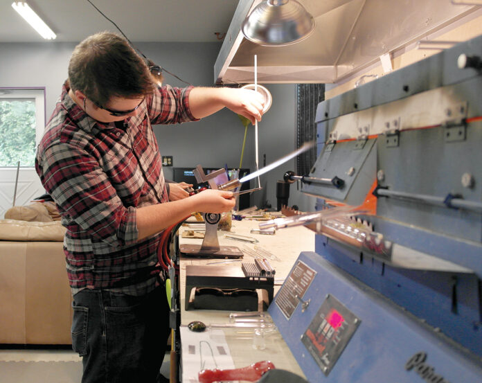 GLASSWORK: Ben Kurose, owner of Greenwich Bay Glass, pulls a gather, or hot ball of glass, to stretch it into a stringer, or thin rod of glass, which is used to apply small detail work.  / COURTESY GREENWICH BAY GLASS