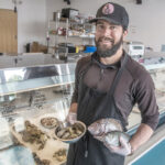 FRESH VARIETY: Stu Meltzer, owner of Fearless Fish Market in Providence, shows off Watch Hill oysters, quahogs, a scup and a bluefish.   / PBN PHOTO/MICHAEL SALERNO