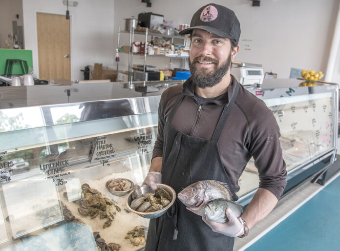 FRESH VARIETY: Stu Meltzer, owner of Fearless Fish Market in Providence, shows off Watch Hill oysters, quahogs, a scup and a bluefish.   / PBN PHOTO/MICHAEL SALERNO