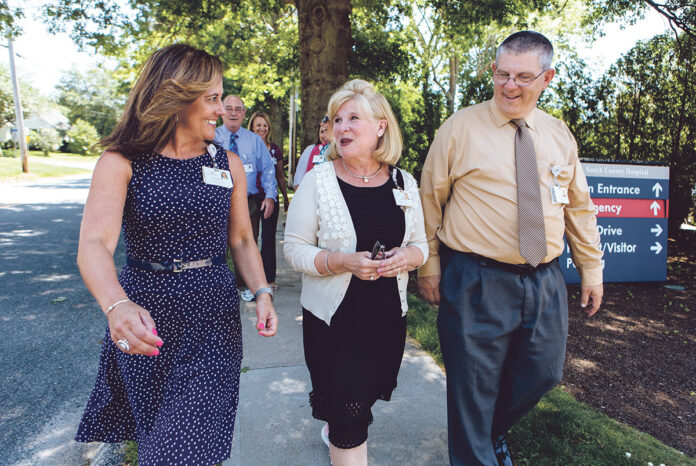 MORE THAN PEDESTRIAN: South County Health employees, from left, Susan Woodard, Mary Phillips and David Fogerty join co-workers outside South County Hospital in South Kingstown for their regular walk around the campus for exercise.  / PBN PHOTO/RUPERT WHITELEY