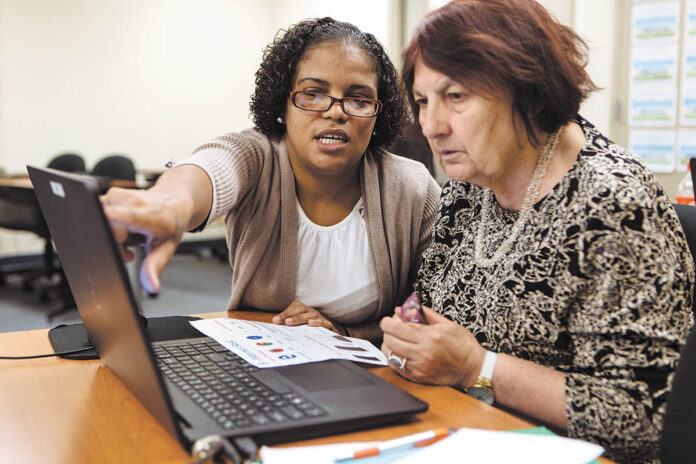 COMPUTER CLASS: Instructor Betty Tavares, left, gives a helping hand to student Lily Minaeliam during an adult digital-literacy workshop at Providence Public Library. PBN PHOTO/RUPERT WHITELEY