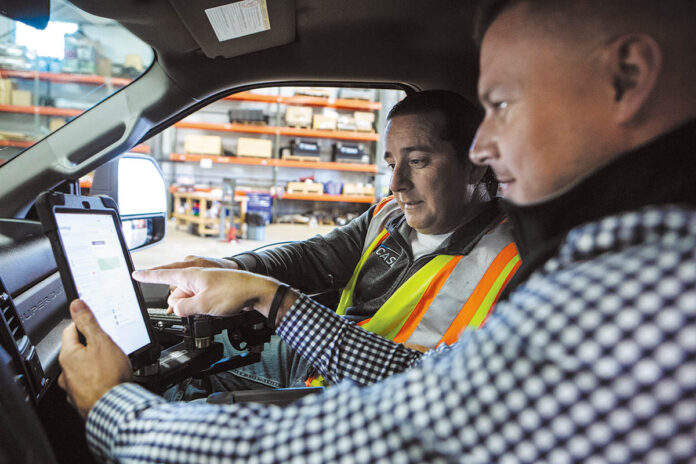 PLANNING AHEAD: Nate Fiske, right, Case Snow Management Inc. regional director of operations, and shop foreman Ken Maynard equip one of the company’s trucks with a tablet loaded with Case’s management software. PBN PHOTO/RUPERT WHITELEY