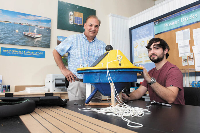 WATER FEATURE: PowerDocks Managing Partner Anthony Baro, left, is with mechanical engineer Dan Servant at the company’s Fall River facility. Servant is working on a prototype remote monitoring buoy that can gather and transmit aquaculture data to shore. PBN PHOTO/DAVE HANSEN