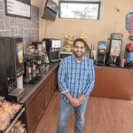 NEW MARKET: Hassan Namat-Ullah is a co-owner of the new University Mart on Empire Street in Providence. The market features snack foods, bottled soda, milk and some perishables, as well as CBD products and a Bitcoin machine.  / PBN PHOTO/MICHAEL SALERNO
