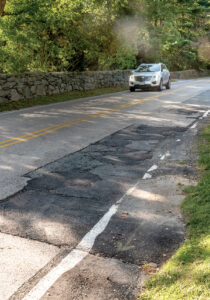PATCHED: The road near 425 Love Lane, covered with patches and cracks, shows the deteriorated condition of some roads in Warwick. The city is planning a $17-$20 million repaving project, which Mayor Joseph J. ­Solomon hopes will return many of the roads to a ­manageable condition.  / PBN PHOTO/MICHAEL SALERNO