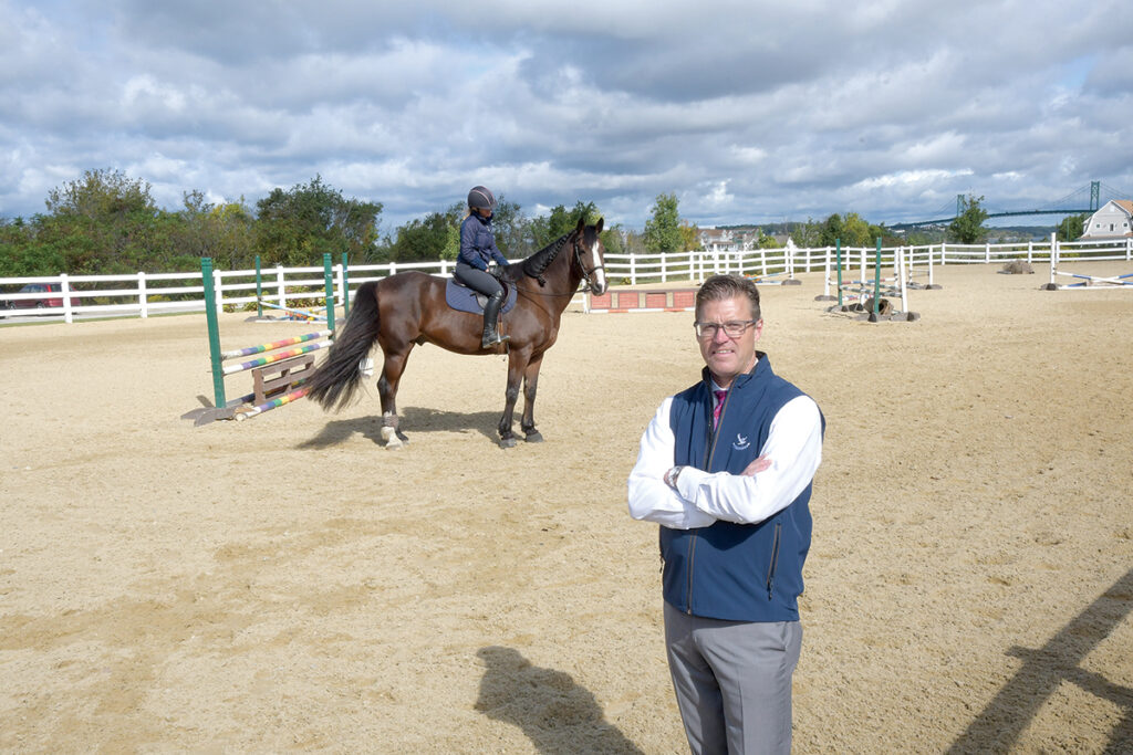 RIDING HIGH: Ron Woods, general manager of The Aquidneck Club in Portsmouth, is pictured at the club’s equestrian center. He says the challenge for golf clubs in Rhode Island is that supply exceeds demand, adding that “the best operators and the best experience operators are going to survive.”  / PBN PHOTO/MIKE SKORSKI