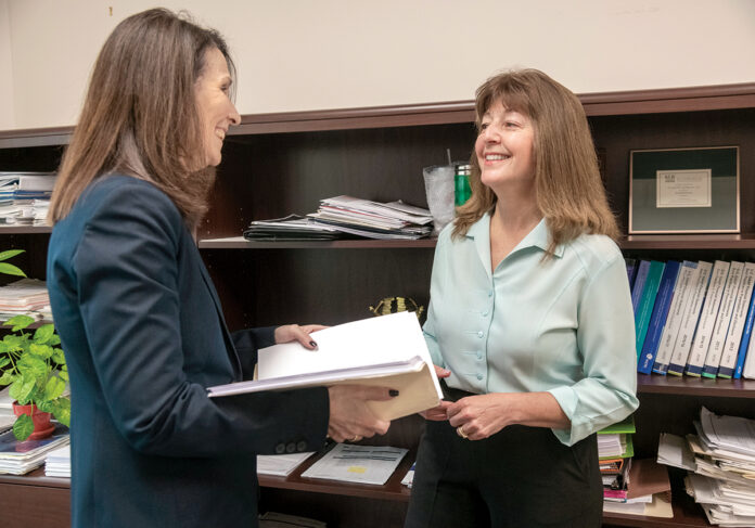 ADDITIONAL CALCULATIONS: Claire Iacobucci, right, partner and director of audit services at Providence accounting firm Kahn, Litwin, Renza & Co., speaks with June Landry, partner and chief marketing officer. Iacobucci said new reporting requirements for companies leasing assets longer than a year involve more accounting work.  / PBN PHOTO/MICHAEL SALERNO