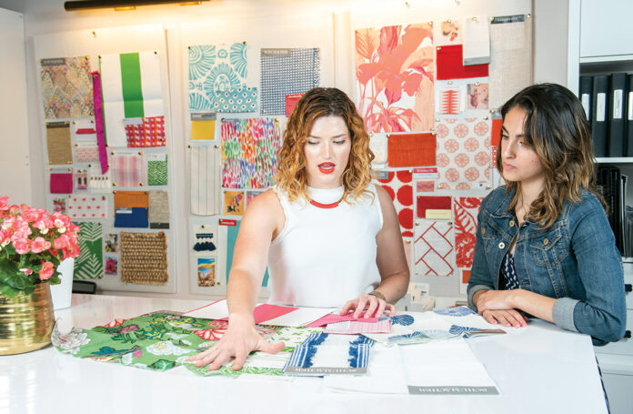 BUILDING A CAREER BY HAND: Rebecca Slater, left, design project director at Blakely Interior Design in North Kingstown, helps Brianna Chace, a New England Tech interior design major and intern at Blakely.  / PBN PHOTO/DAVE HANSEN