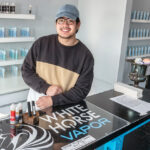 UP IN SMOKE: White Horse Vapor employee Joey Chen shows some of the products the vape shop carries. Owner Dino Baccari said a recent statewide ban on flavored e-cigarettes forced him to close his White Horse Vapor location in Warwick. / PBN PHOTO/MICHAEL SALERNO