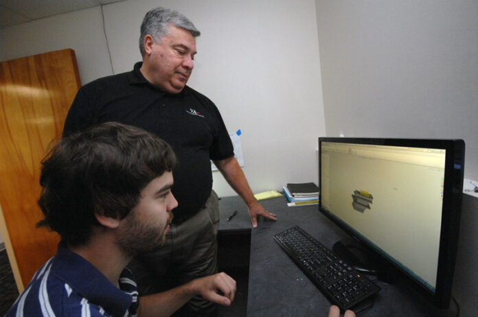 VETERANS ASSEMBLED ELECTRONICS founder and CEO John Shepard, standing, works with mechanical engineer Michael Ratigan at VAe in 2017. / PBN FILE PHOTO/BRIAN MCDONALD