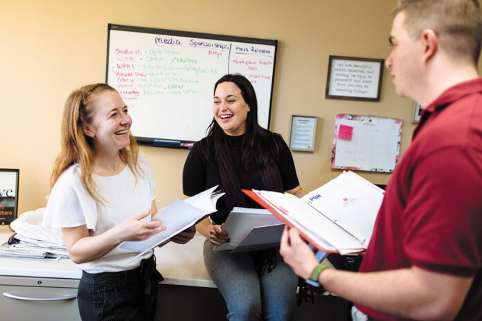 HEALTHY SMILES: From left, Jamie Oriol, field support coordinator; Samantha Bowen, director of communications and intern Austin Prario discuss their tasks at the American Heart Association of Southern New England in Providence. / PBN PHOTO/RUPERT WHITELEY 