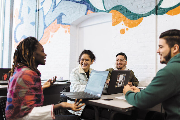 HIGHER LEARNING: From left, College Crusade of Rhode Island high school adviser Agi Kah and middle school advisers Manuela Garcia, Victor Martinez and Eric Rossi have a conversation at the organization’s Providence headquarters. / PBN PHOTO/RUPERT WHITELEY