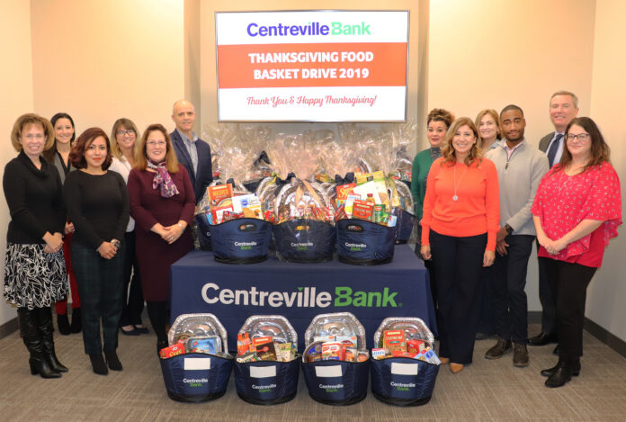 CENTREVILLE BANK STAFF stand with some of the 21 Thanksgiving food baskets the bank assembled with donations it received at its seven branches during its annual Thanksgiving food drive. / COURTESY CENTREVILLE BANK