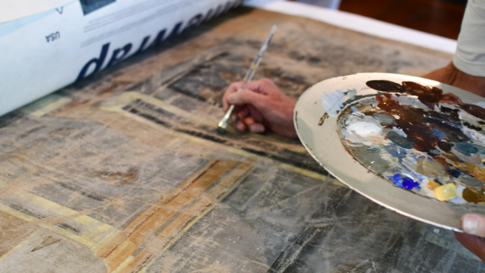 CONSERVATORS APPLY minimal amounts of paint to a 200-year-old theater drop curtain in an effort to restore it. / COURTESY RHODE ISLAND HISTORICAL SOCIETY