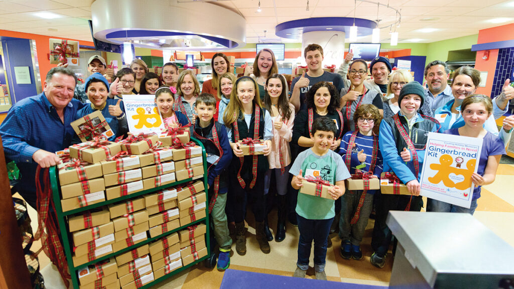 HOLIDAY HELPERS: Volunteers assemble hundreds of Warm-A-Heart Gingerbread kits, which are sold at Lifespan health care facilities and Dave’s Fresh Marketplace stores. The proceeds go to nonprofits assisting families in need. / COURTESY GRACIE’S  
