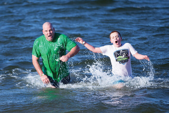 BRAVING BRISK TEMPS: Two participants in the 2019 Laid-back Fitness Frozen Clam Dip and Obstaplunge react to the temperature of the water in Narragansett Bay on New Year’s Day. The 2020 plunge will take place Jan. 1 at Goddard Memorial State Park in East Greenwich. / COURTESY LAID-BACK FITNESS