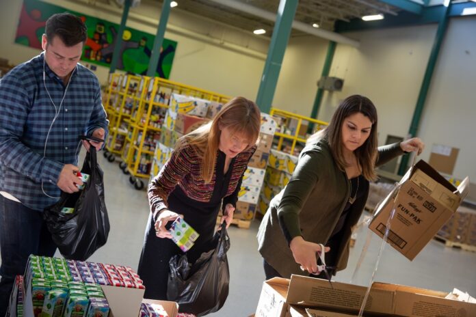 VOLUNTEERS SORT items at the Rhode Island Community Food Bank, one of seven social service agencies sharing $180,000 in emergency year-end grants from the Rhode Island Foundation. / COURTESY CONNIE GROSCH/RHODE ISLAND FOUNDATION